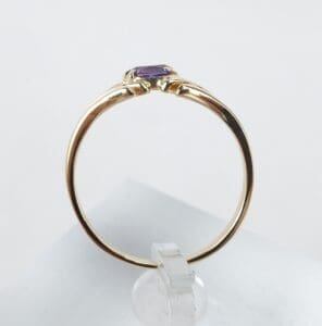 Gold ring with a purple gemstone.