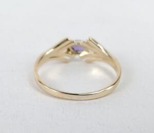 Gold ring with purple gemstone setting.