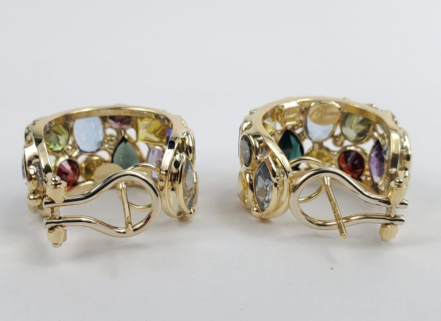 Gold earrings with colorful gemstones displayed.