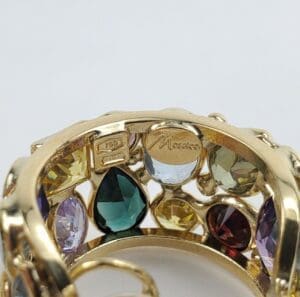 Gold ring with colorful gemstones and engravings.
