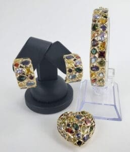 Colorful gemstone jewelry set on display stands.
