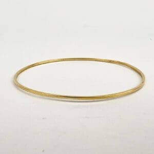 Gold bangle on white background.
