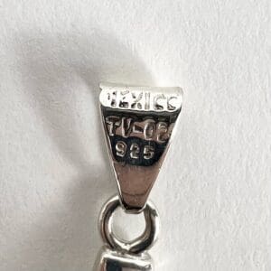 Silver pendant bail with engraved markings.