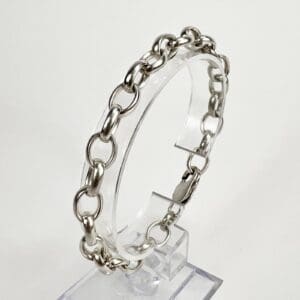 Silver chain bracelet on clear stand.