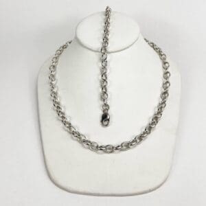 Silver chain necklace on white display bust.