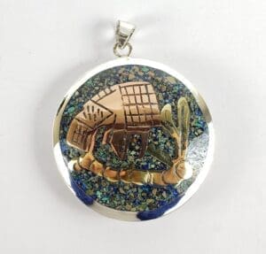 Round pendant with abstract animal design.