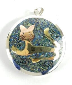 Cat pendant with blue speckled background.