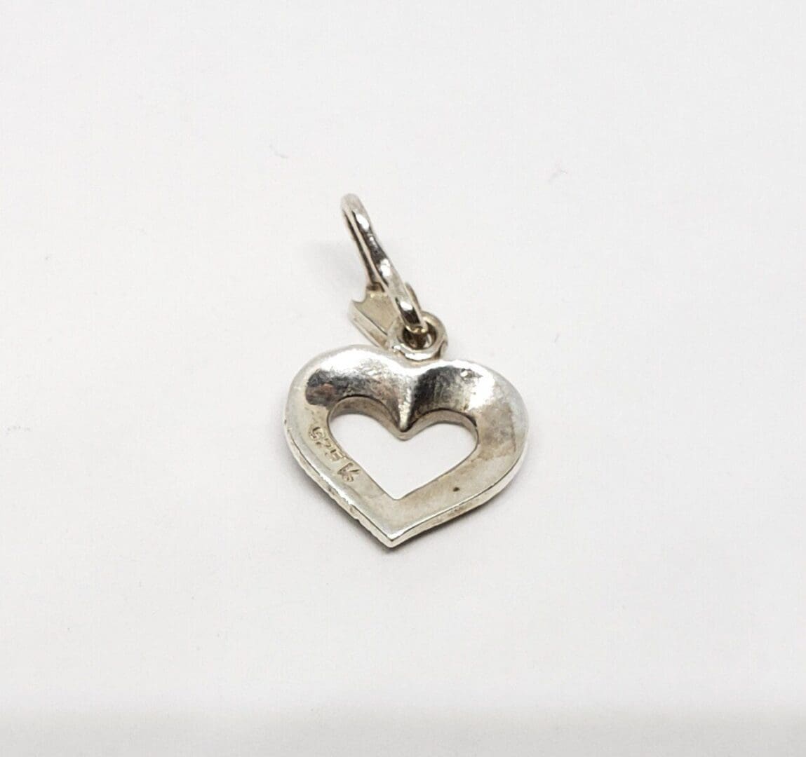 Silver heart-shaped pendant on white background.