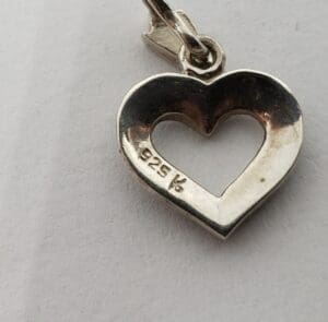 Silver heart-shaped pendant with "925" inscription.