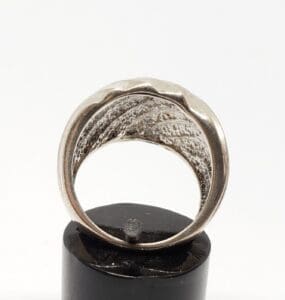 Silver ring on black display stand.