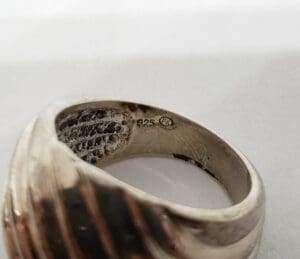 Silver ring with engraved markings inside band.