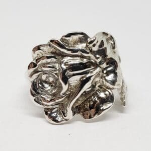 Silver rose-shaped ring on white background.
