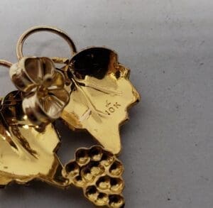 Gold pendant with leaves and grapes.