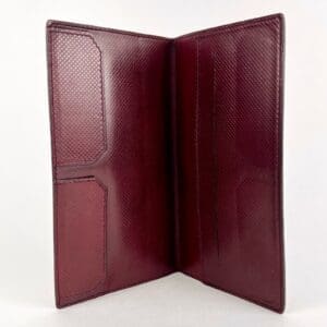 Open red leather wallet with card slots.