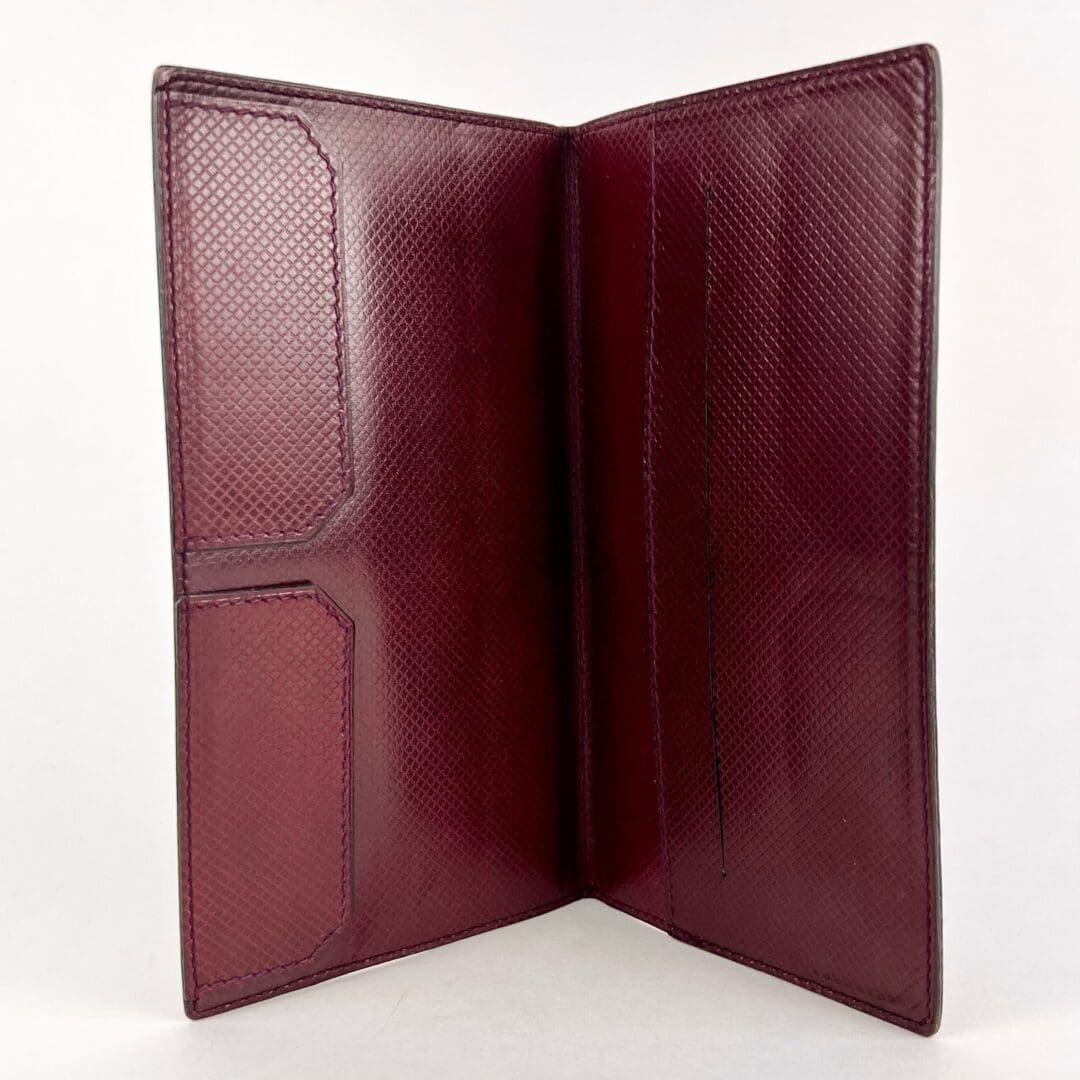 Open red leather wallet with card slots.