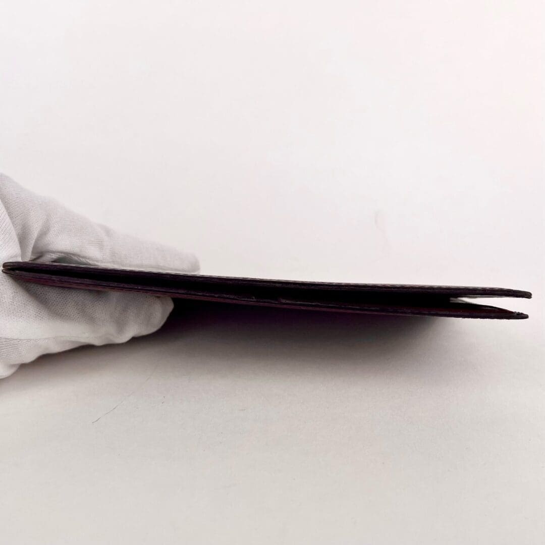 Gloved hand holding a thin black object.
