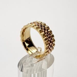 Golden textured ring on clear stand.