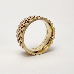 Gold ring with scalloped edge design.