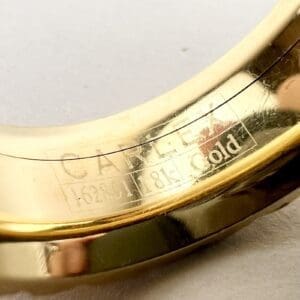 Gold bracelet with engraved text detail.