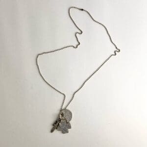 Necklace with cross and circular pendants.