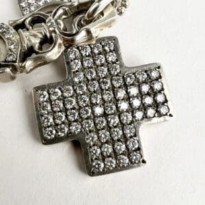 Diamond-studded cross pendant with ornate chain.
