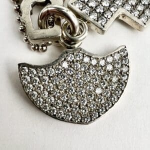 Silver and diamond-studded pendant on chain.