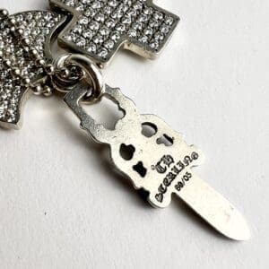 Silver cross and keychain with engravings.