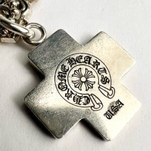 Silver cross pendant with engraved design.