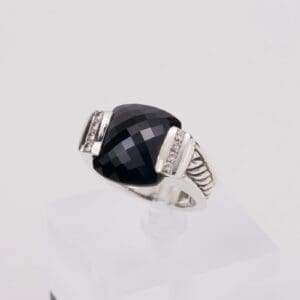 Silver ring with large black gemstone.