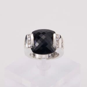 Silver ring with large black gemstone.