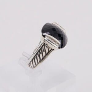 Silver ring with large black gemstone.