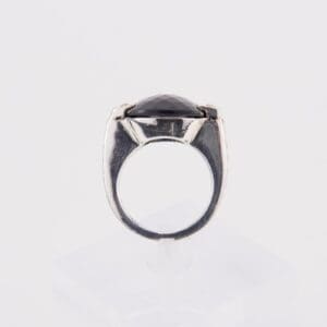 Silver ring with black gemstone, side view.