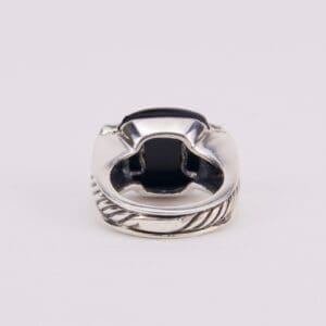 Silver ring with black gemstone, intricate design.