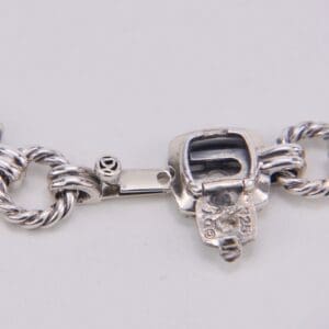 Silver bracelet clasp with intricate design.