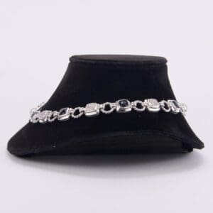 Silver bracelet on black velvet display.