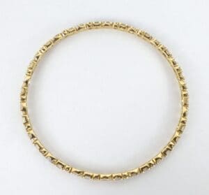 Gold bracelet with textured design pattern.