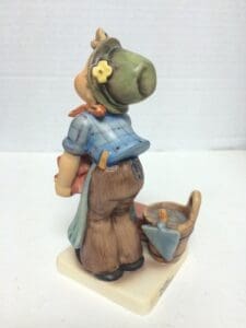 Figurine of a child with gardening tools.