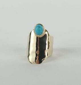 Gold ring with blue oval gemstone.