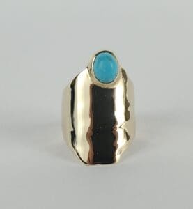 Gold ring with blue stone setting.