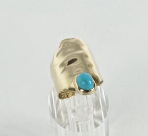 Gold ring with turquoise stone detail.