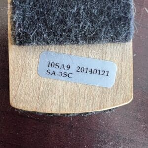 Wooden brush with a label and bristles.