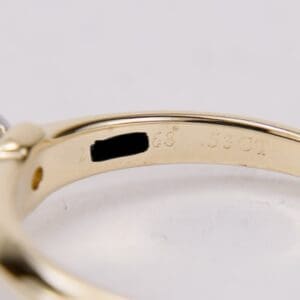 Gold ring with engraved markings inside band.