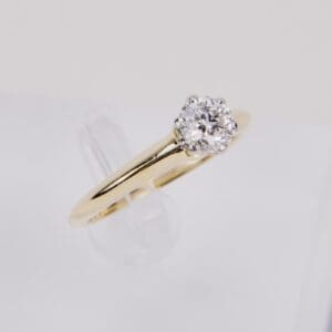 Gold ring with single diamond on display.