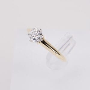 Gold ring with solitaire diamond on display.