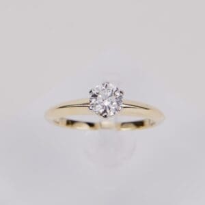 Gold ring with solitaire diamond centerpiece.