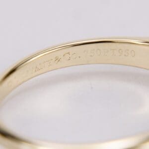 Gold ring with engraved text inside.
