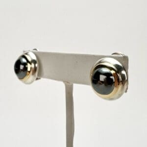 Gold and black round stud earrings display.