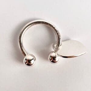 Silver circular jewelry with heart charm.