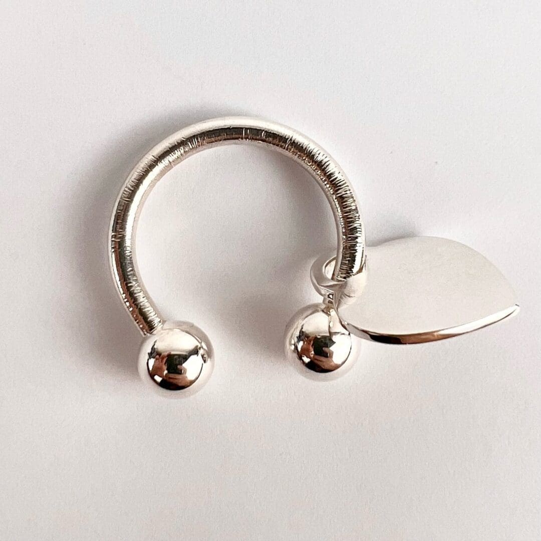 Silver circular jewelry with heart charm.