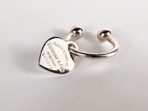 Heart-shaped silver ring with engraved inscription.